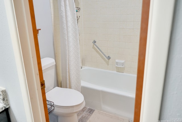 bathroom featuring toilet and shower / bathtub combination with curtain