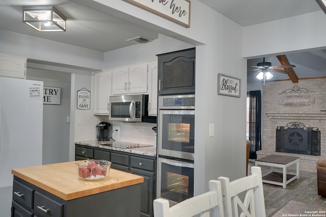 kitchen with gray cabinetry, white cabinets, appliances with stainless steel finishes, dark hardwood / wood-style flooring, and butcher block counters