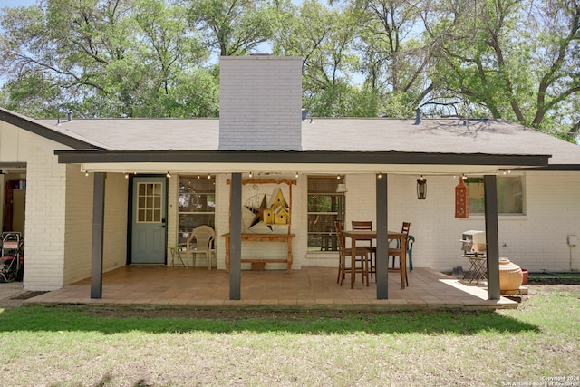 back of property featuring a lawn and a patio area