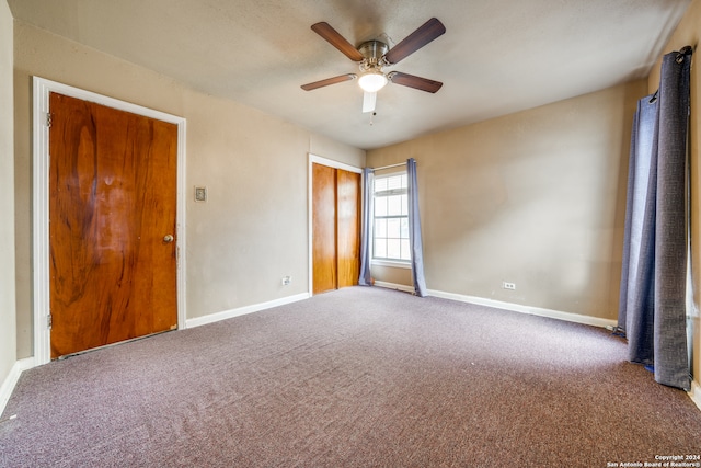 carpeted spare room with ceiling fan