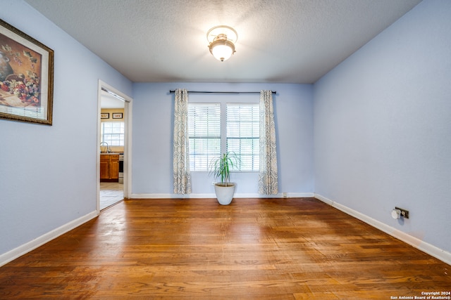 unfurnished room featuring hardwood / wood-style floors and a textured ceiling