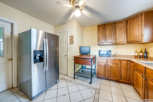 kitchen with appliances with stainless steel finishes, a textured ceiling, light tile patterned floors, and ceiling fan