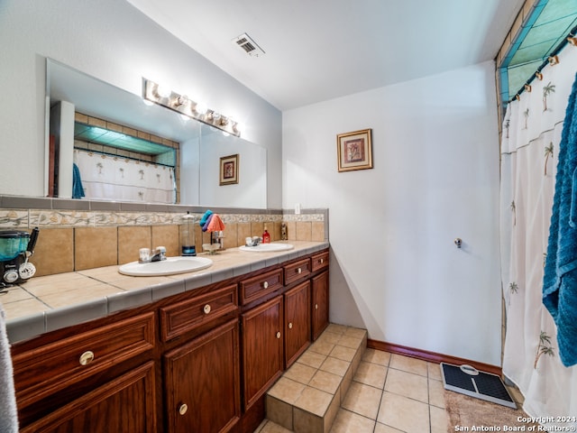 bathroom featuring backsplash, curtained shower, tile patterned flooring, and vanity