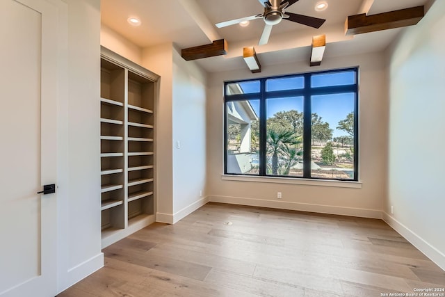 unfurnished room featuring beam ceiling, ceiling fan, built in features, and light hardwood / wood-style floors