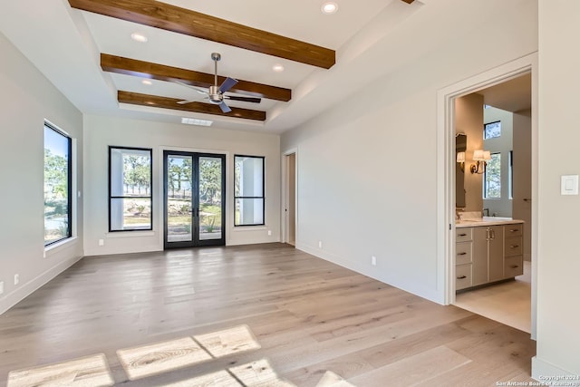 unfurnished room featuring beamed ceiling, french doors, light hardwood / wood-style floors, and ceiling fan