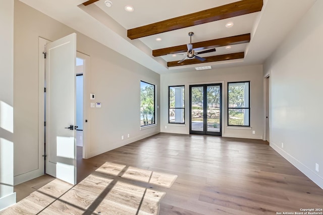 spare room with ceiling fan, french doors, beamed ceiling, and wood-type flooring