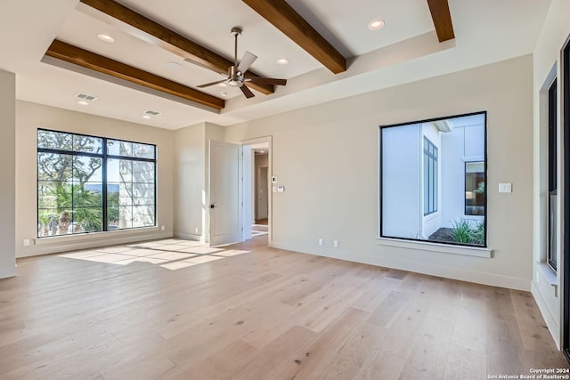 spare room featuring a raised ceiling, ceiling fan, beamed ceiling, and light wood-type flooring