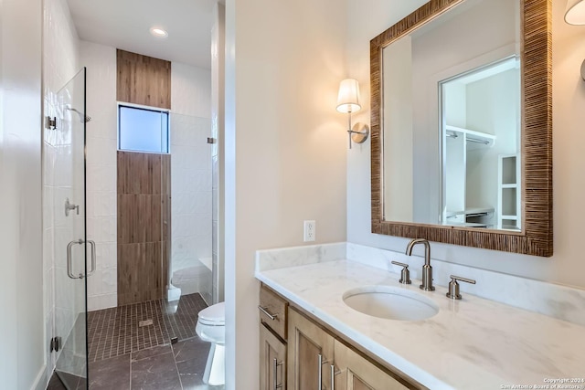 bathroom featuring tile patterned floors, vanity, toilet, and a shower with door