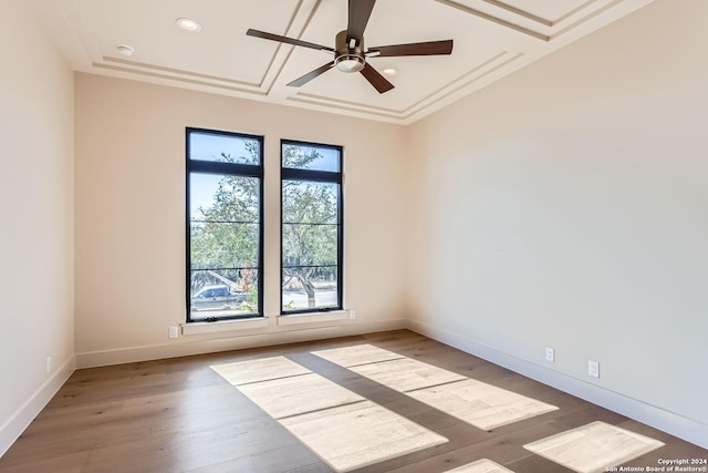 empty room with ceiling fan, coffered ceiling, and hardwood / wood-style flooring