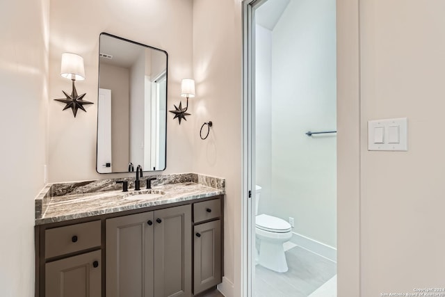 bathroom featuring tile patterned floors, vanity, and toilet