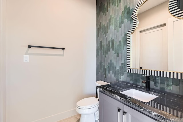 bathroom featuring tile patterned flooring, vanity, toilet, and backsplash