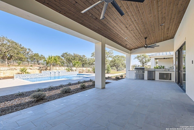 view of patio with area for grilling, ceiling fan, and exterior kitchen