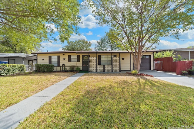 single story home featuring a garage and a front yard