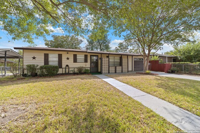 ranch-style home featuring a garage and a front lawn