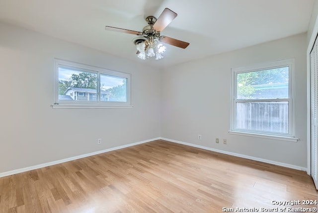 empty room with ceiling fan, light hardwood / wood-style floors, and a wealth of natural light