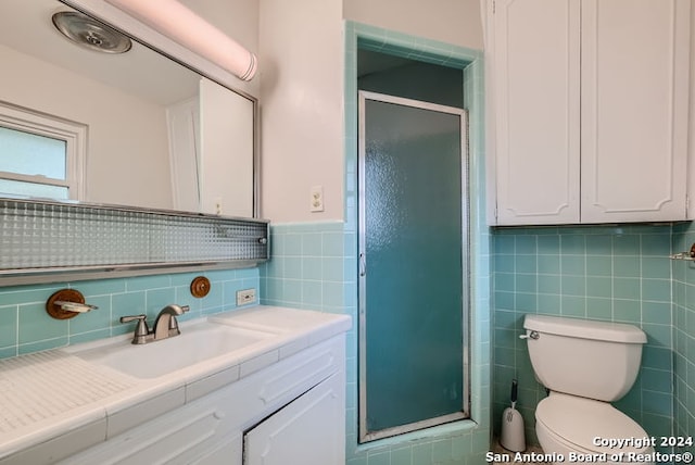 bathroom featuring vanity, an enclosed shower, and tile walls