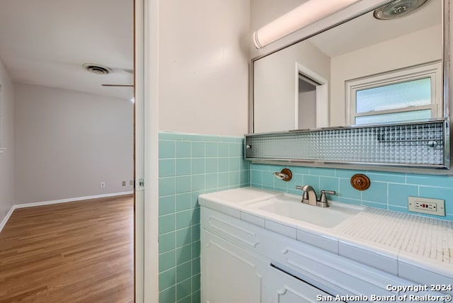 bathroom featuring hardwood / wood-style floors, vanity, and tile walls