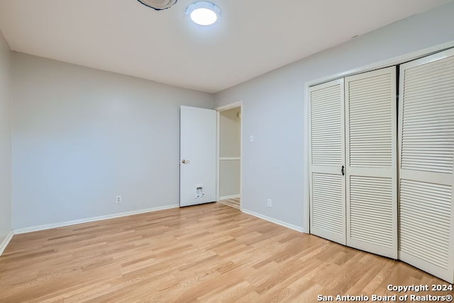 unfurnished bedroom featuring a closet and light wood-type flooring