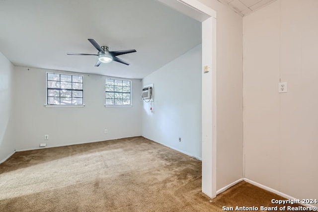 spare room featuring carpet floors, an AC wall unit, and ceiling fan