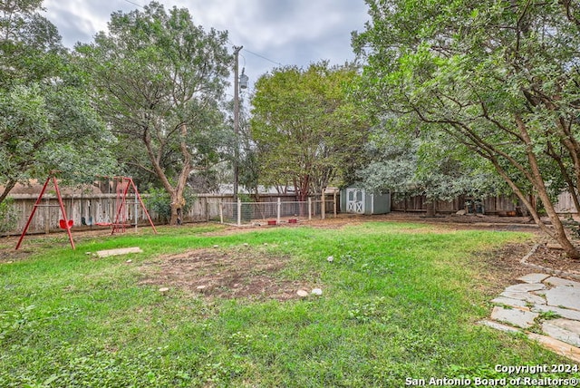 view of yard featuring a playground and a storage unit