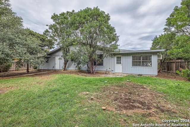 rear view of property with a lawn