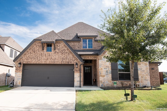 view of front facade with a garage and a front lawn