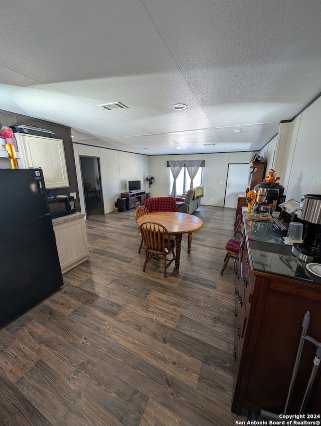 dining space with a textured ceiling and dark hardwood / wood-style floors