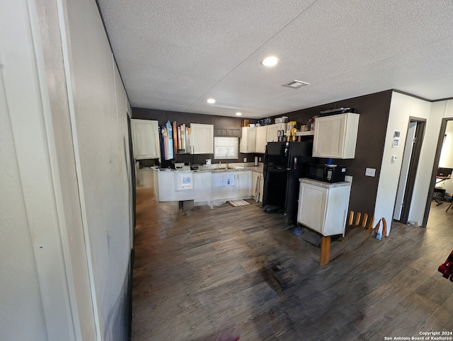 kitchen featuring black appliances, dark hardwood / wood-style floors, white cabinetry, and a textured ceiling