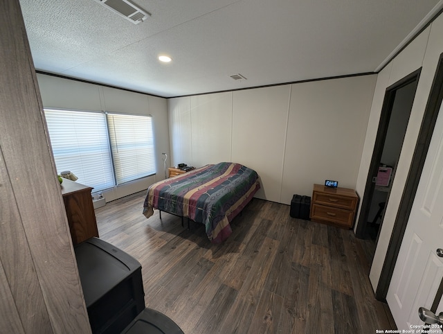 bedroom with a textured ceiling and dark hardwood / wood-style flooring