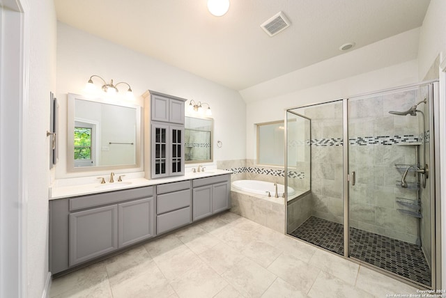 bathroom with vanity and shower with separate bathtub