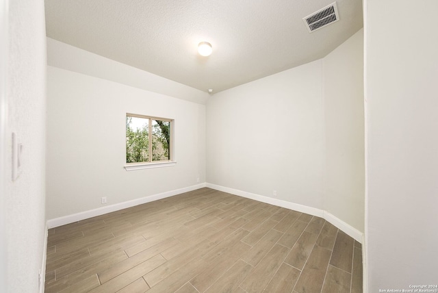 spare room with wood-type flooring and a textured ceiling