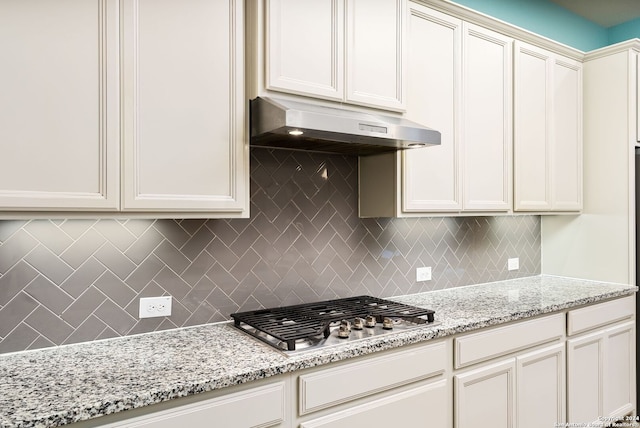 kitchen featuring light stone countertops, tasteful backsplash, and stainless steel gas stovetop