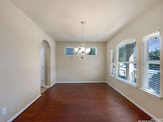 unfurnished dining area featuring dark hardwood / wood-style flooring and a notable chandelier