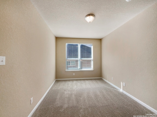 carpeted spare room with a textured ceiling