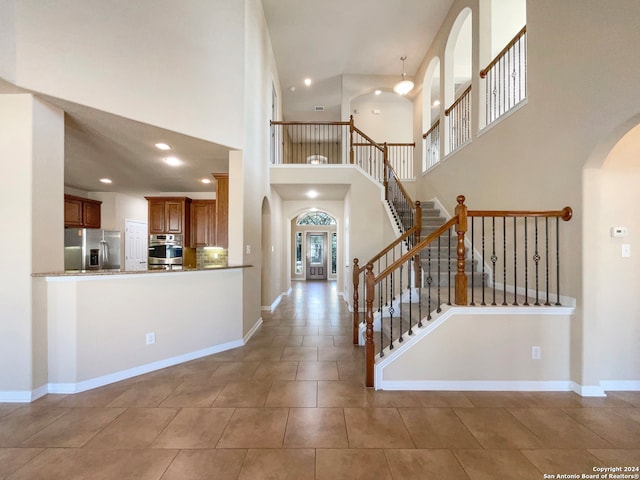 entrance foyer featuring light tile patterned flooring and a high ceiling