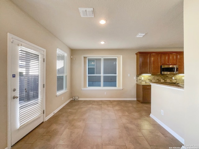 kitchen with decorative backsplash, light tile patterned floors, and a textured ceiling