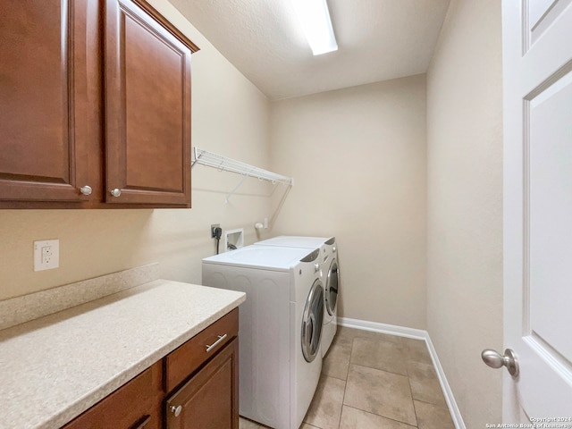 laundry area featuring cabinets, independent washer and dryer, and light tile patterned floors