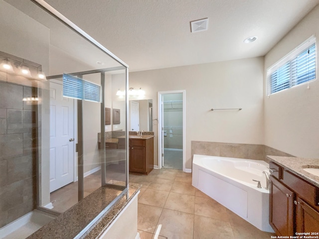 bathroom featuring tile patterned floors, vanity, a textured ceiling, and shower with separate bathtub