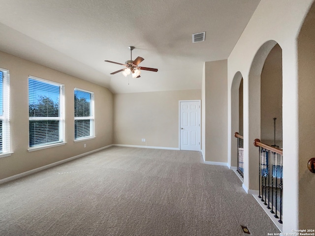 unfurnished room with ceiling fan, light colored carpet, and a textured ceiling