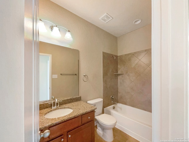 full bathroom featuring vanity, tiled shower / bath combo, and toilet