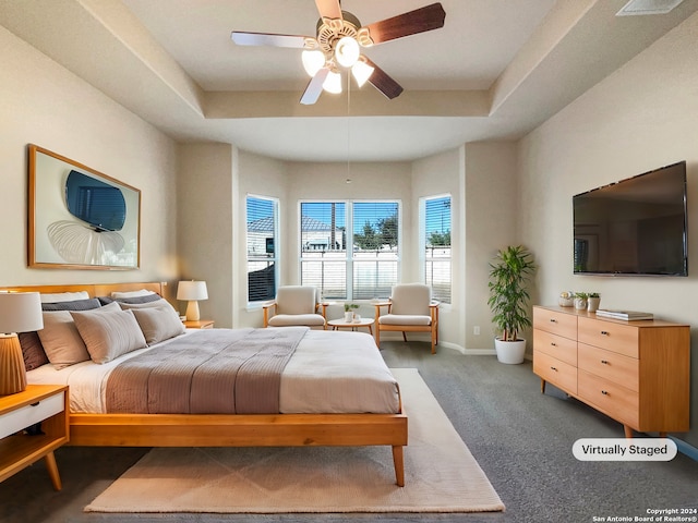 carpeted bedroom featuring a raised ceiling and ceiling fan