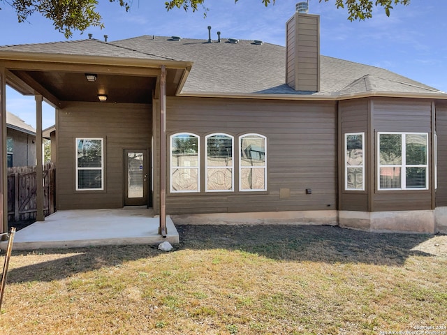 back of property with a yard and a patio