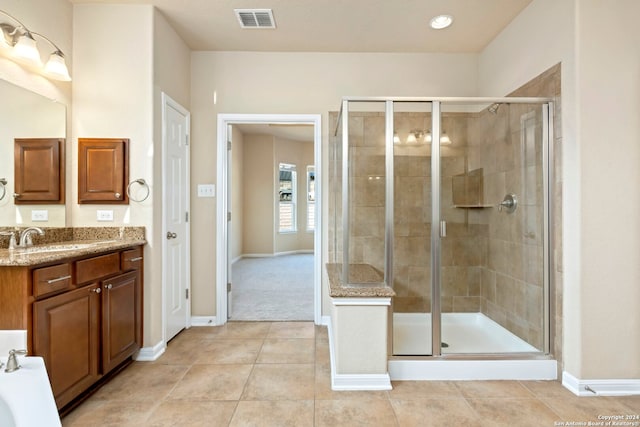 bathroom with tile patterned floors, vanity, and walk in shower