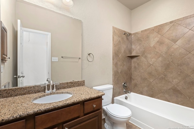 full bathroom featuring tiled shower / bath combo, toilet, and vanity