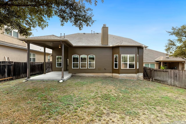 rear view of house featuring a yard and a patio