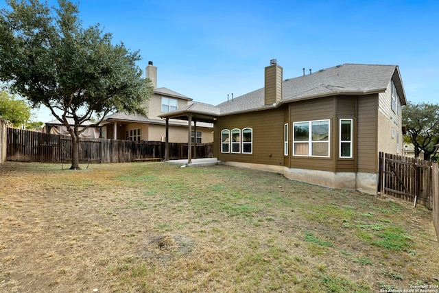 back of property featuring a lawn