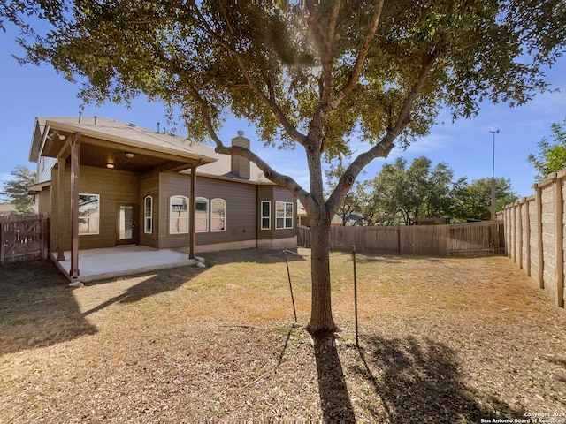 back of house featuring a yard and a patio