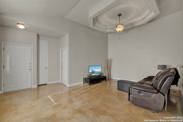 living room featuring a tray ceiling and ceiling fan