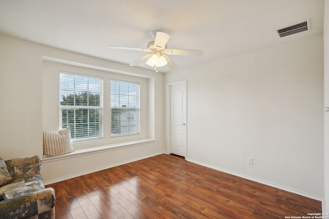 unfurnished room with ceiling fan and dark wood-type flooring