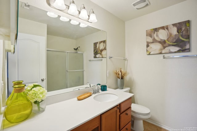 bathroom featuring a shower with door, vanity, and toilet